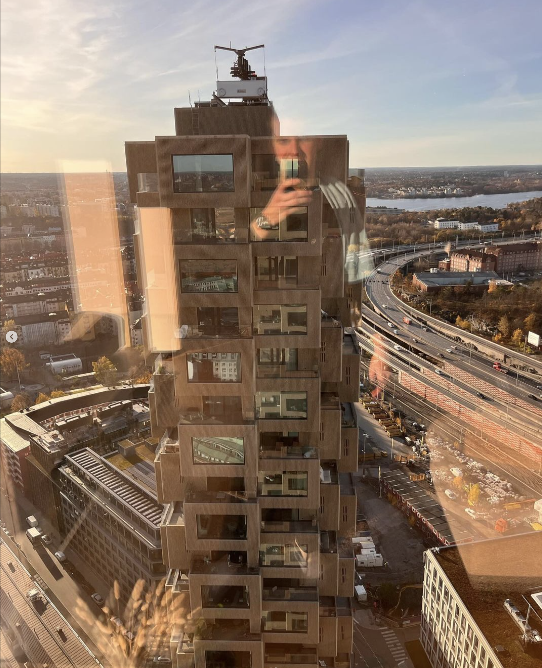 Fönsterputsare utför fönsterputs högst upp i Norra Tornen, tar bild på andra tornet och ser ut över Stockholm från hög höjd.