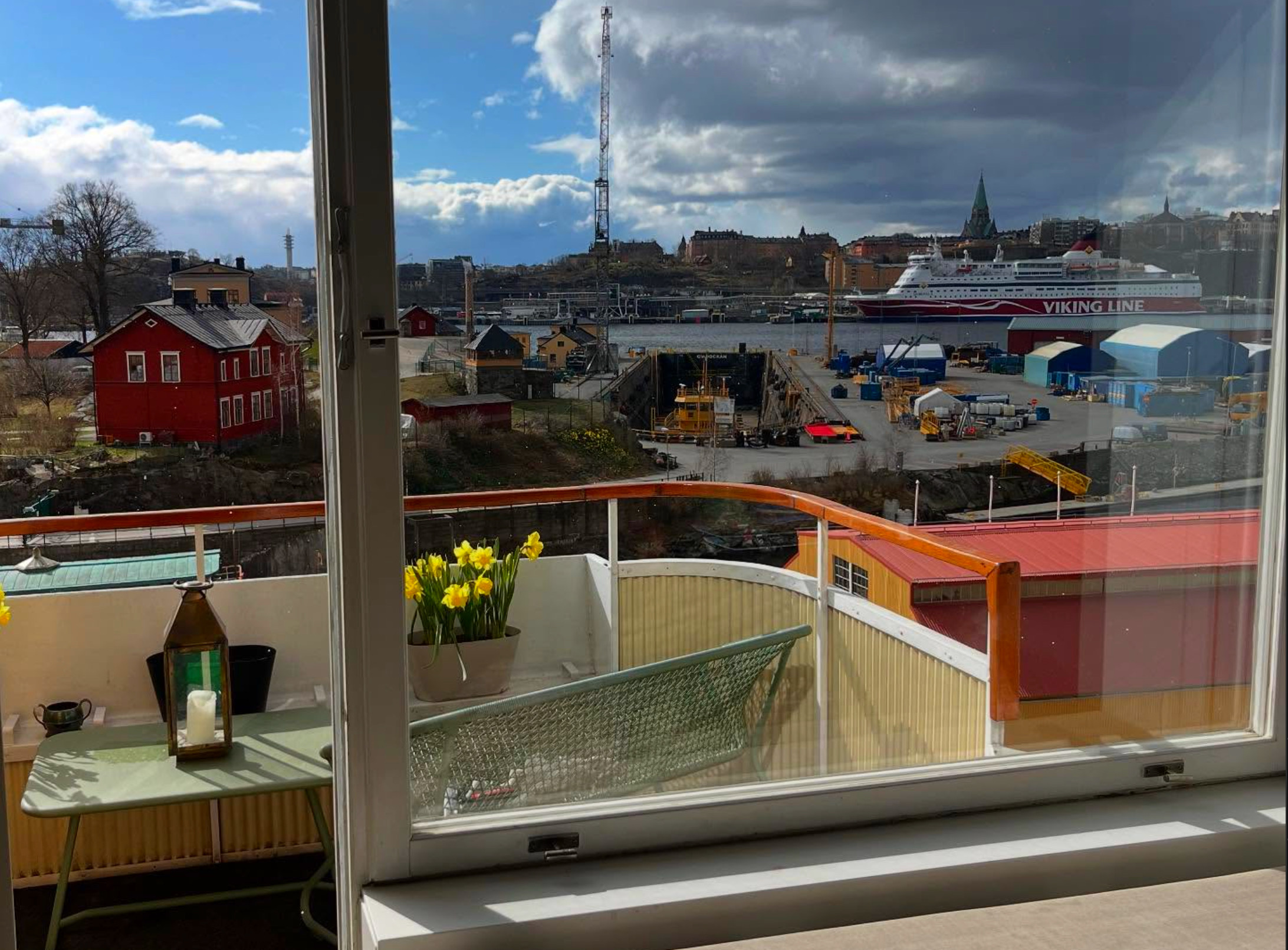 Stort fönster på Djurgården med utsikt över sjön och kryssningsbåt – professionell fönsterputs i Stockholm med vacker sjöutsikt.